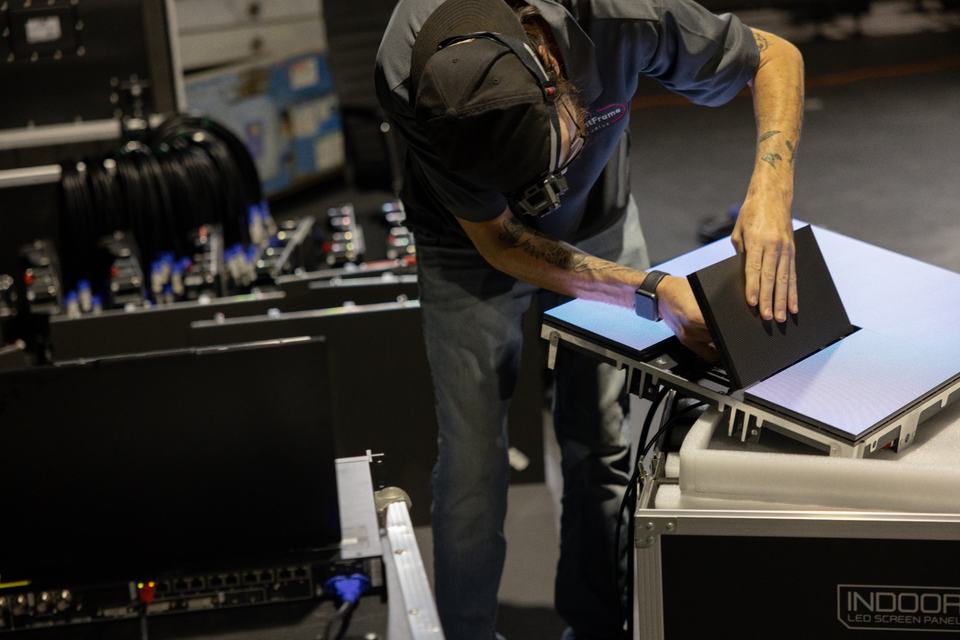 Bright Frame quality control technician hand-inspecting an indoor LED panel before packing